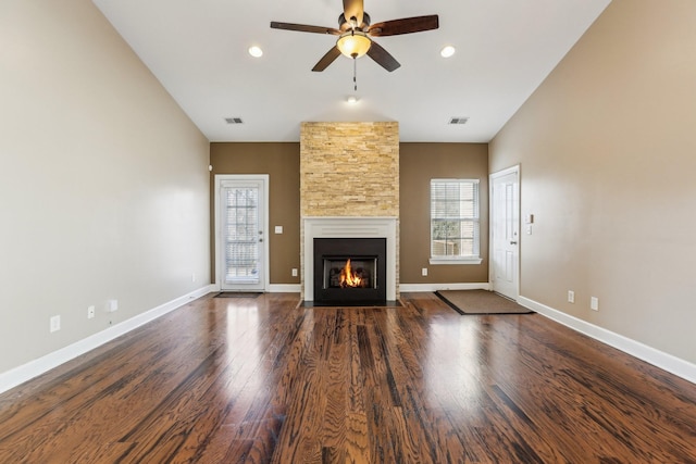 unfurnished living room with a fireplace, wood finished floors, visible vents, and baseboards