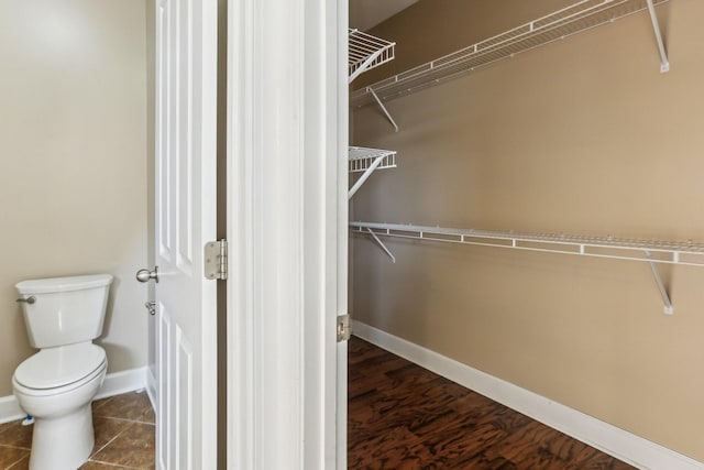 walk in closet featuring dark tile patterned flooring