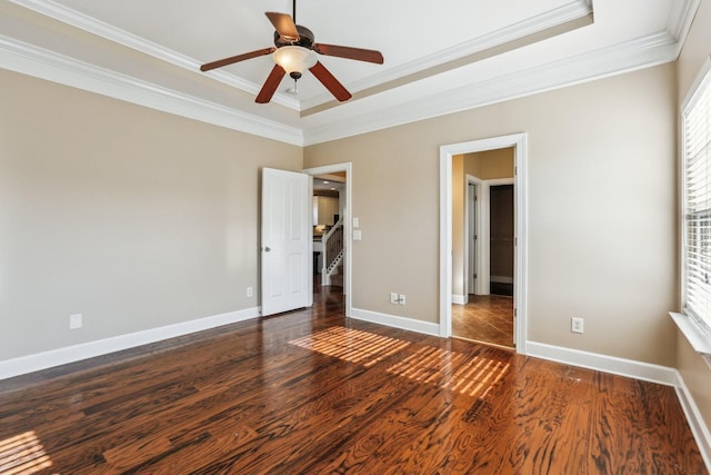 unfurnished bedroom featuring a ceiling fan, crown molding, baseboards, and wood finished floors