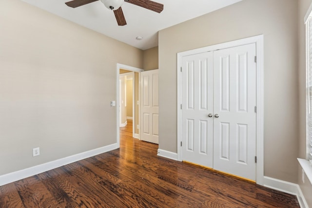 unfurnished bedroom with a ceiling fan, a closet, dark wood finished floors, and baseboards