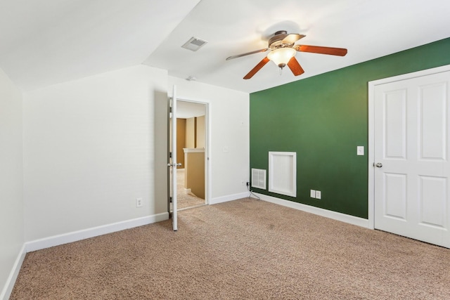 unfurnished bedroom with lofted ceiling, carpet flooring, visible vents, and baseboards