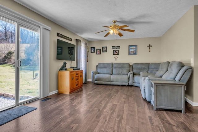 living area with a textured ceiling, dark wood finished floors, and visible vents