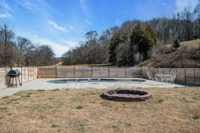 view of swimming pool with a fenced backyard, area for grilling, a yard, a fenced in pool, and a patio area