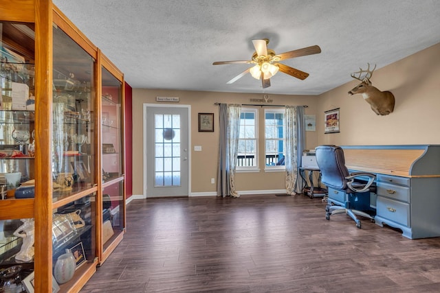 office area featuring ceiling fan, a textured ceiling, baseboards, and dark wood-type flooring