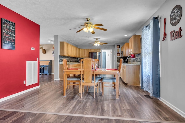 dining room featuring baseboards, a textured ceiling, visible vents, and dark wood-type flooring