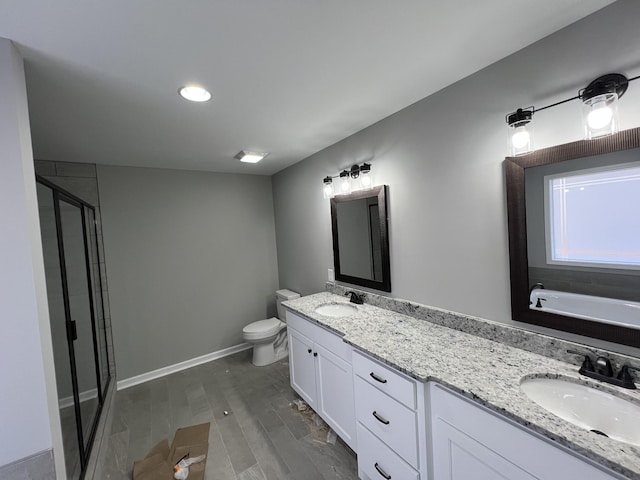 bathroom featuring double vanity, a stall shower, toilet, and a sink