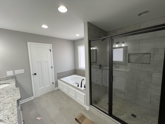 bathroom with a stall shower, baseboards, vanity, a bath, and recessed lighting