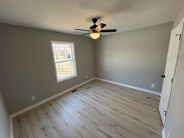 unfurnished bedroom featuring baseboards, ceiling fan, visible vents, and light wood finished floors