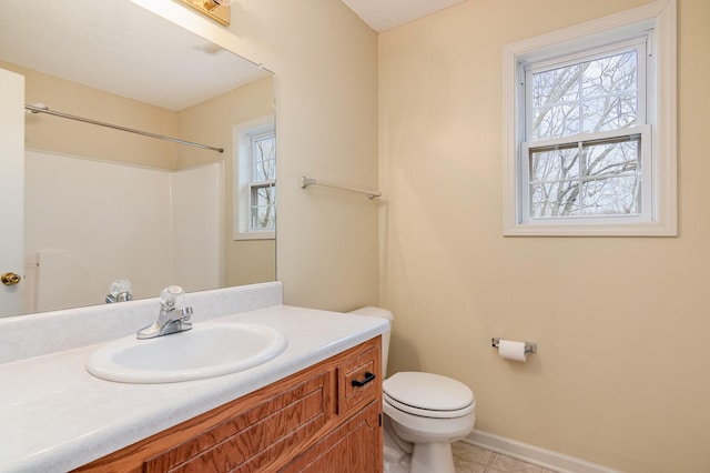 bathroom featuring baseboards, toilet, tile patterned floors, vanity, and a shower