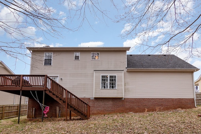 rear view of property with a deck, stairway, fence, and a shingled roof