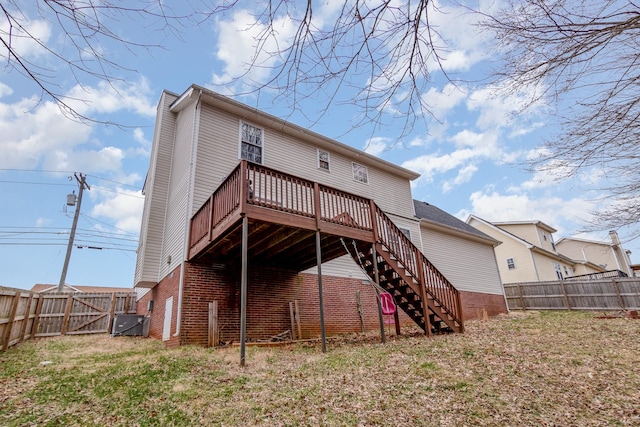 rear view of house with stairway, a fenced backyard, brick siding, and a wooden deck