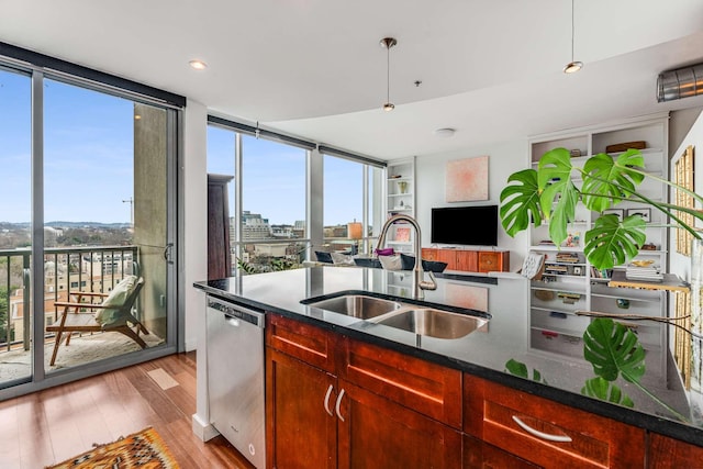 kitchen with a sink, a wall of windows, dishwasher, and wood finished floors