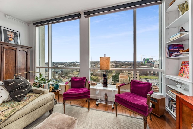 sitting room with expansive windows, wood finished floors, and a wealth of natural light