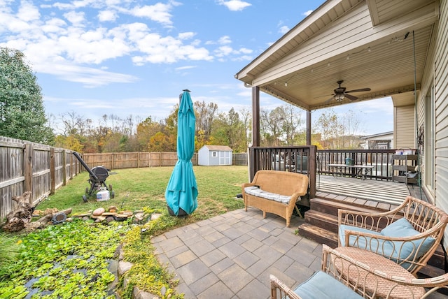 view of patio / terrace featuring an outbuilding, ceiling fan, a storage unit, and a fenced backyard