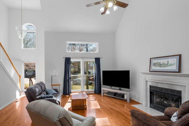 6545 Chessington Dr, Nashville, TN 37221 - living room featuring a towering ceiling, a fireplace with flush hearth, stairs, and wood finished floors