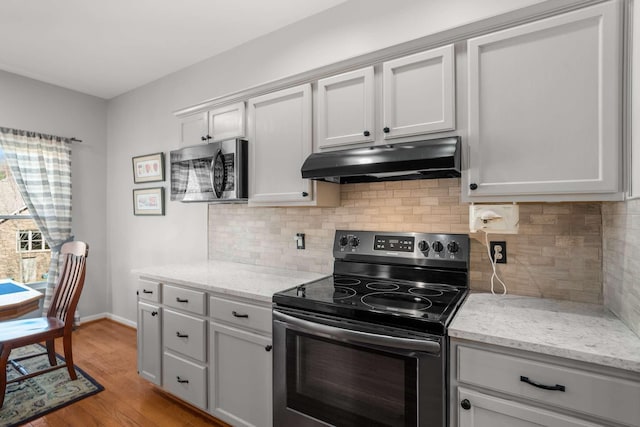 6545 Chessington Dr, Nashville, TN 37221 - kitchen featuring under cabinet range hood, baseboards, light wood-type flooring, black electric range oven, and stainless steel microwave