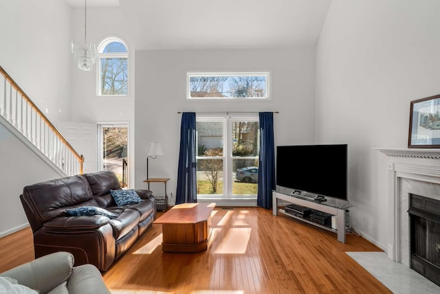 6545 Chessington Dr, Nashville, TN 37221 - living room with a chandelier, a towering ceiling, a high end fireplace, stairs, and wood-type flooring