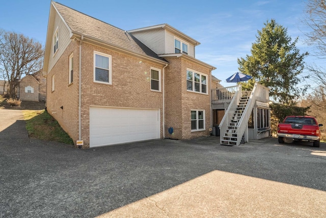 6545 Chessington Dr, Nashville, TN 37221 - exterior space with aphalt driveway, roof with shingles, brick siding, a garage, and stairs
