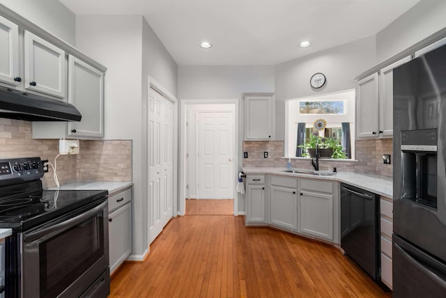 6545 Chessington Dr, Nashville, TN 37221 - kitchen featuring light wood-style flooring, under cabinet range hood, black appliances, a sink, and recessed lighting