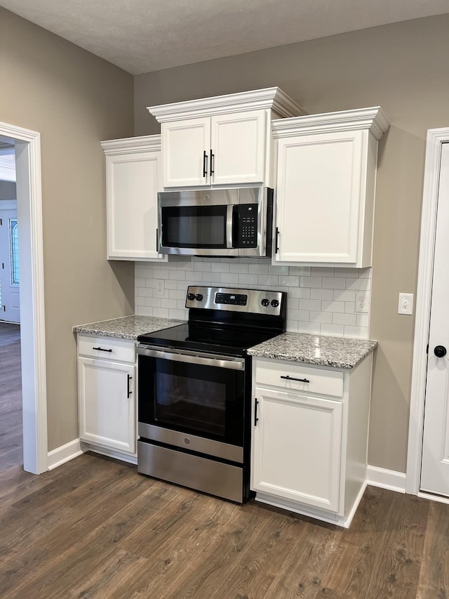 kitchen with appliances with stainless steel finishes, dark wood-style flooring, and backsplash