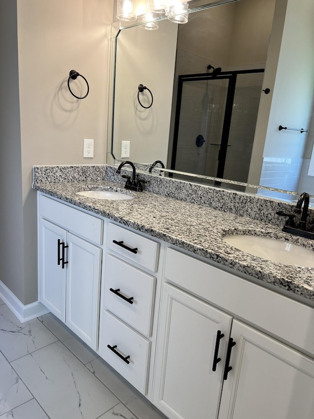 full bath featuring double vanity, marble finish floor, a shower stall, and a sink