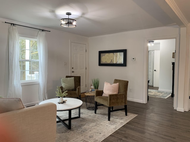 living area featuring dark wood-type flooring, crown molding, and baseboards