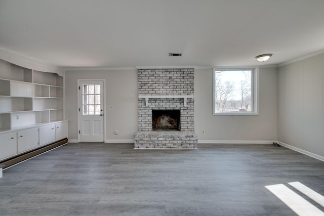 unfurnished living room featuring baseboards, visible vents, ornamental molding, wood finished floors, and a fireplace