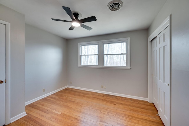 unfurnished bedroom with a closet, light wood-type flooring, visible vents, and baseboards