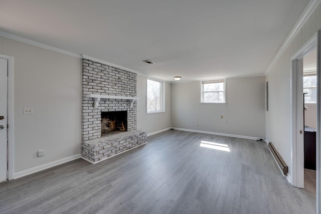 unfurnished living room featuring a fireplace, a baseboard radiator, ornamental molding, wood finished floors, and baseboards