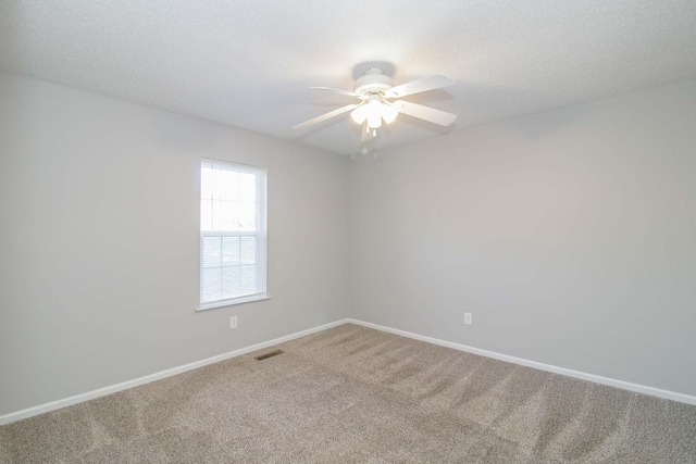 carpeted empty room with a textured ceiling, visible vents, and baseboards