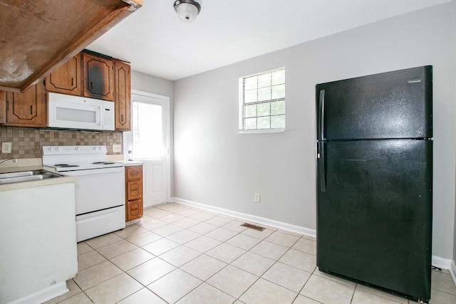 kitchen with a wealth of natural light, light countertops, backsplash, a sink, and white appliances