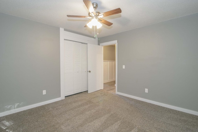 unfurnished bedroom featuring carpet floors, a closet, baseboards, and a textured ceiling