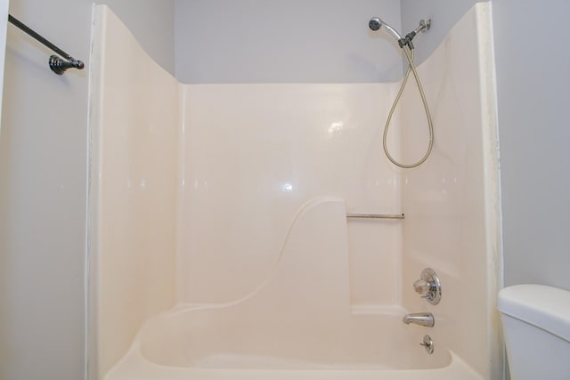 bathroom featuring washtub / shower combination and toilet