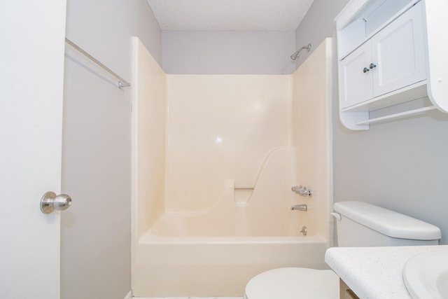 bathroom featuring bathtub / shower combination, vanity, toilet, and a textured ceiling