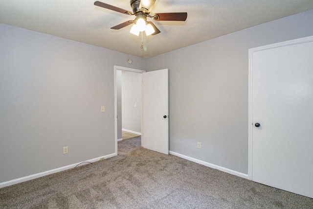 carpeted empty room with a ceiling fan, a textured ceiling, and baseboards