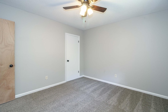 unfurnished room with a ceiling fan, carpet flooring, and baseboards