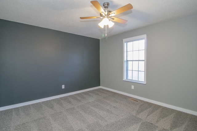 carpeted spare room with ceiling fan, baseboards, and a textured ceiling