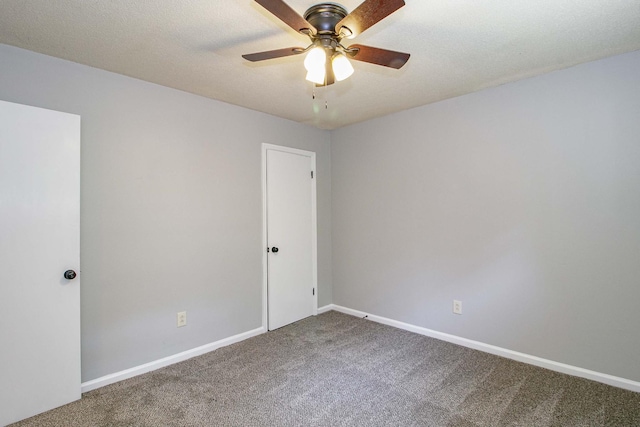 spare room featuring carpet floors, a textured ceiling, baseboards, and a ceiling fan