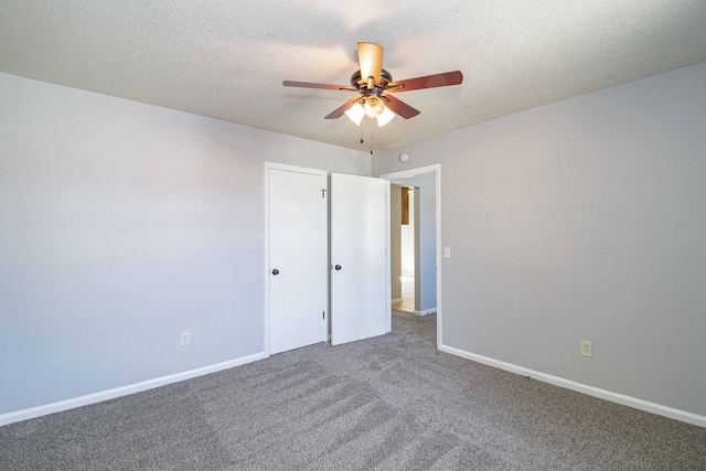 unfurnished bedroom with carpet floors, ceiling fan, baseboards, and a textured ceiling