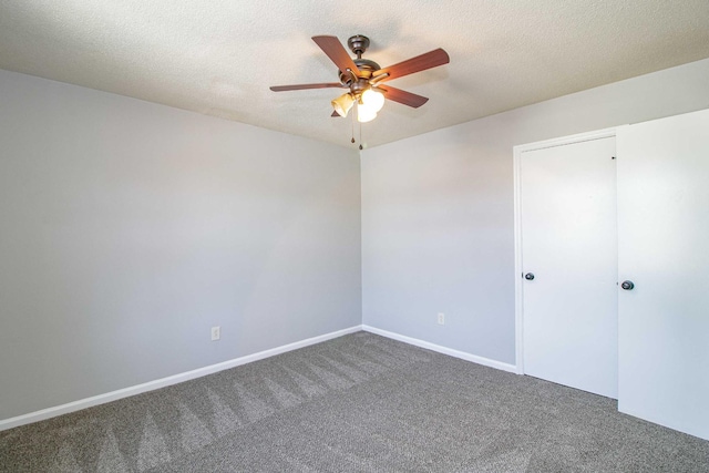 spare room featuring baseboards, carpet, a ceiling fan, and a textured ceiling