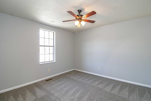 unfurnished room featuring a textured ceiling, carpet flooring, visible vents, and baseboards