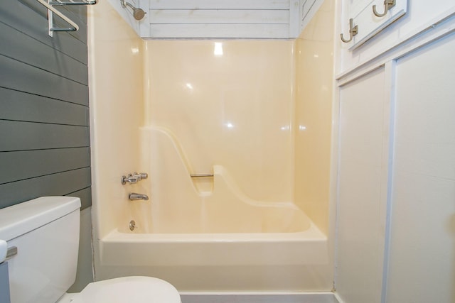 full bathroom with toilet, wooden walls, and tub / shower combination