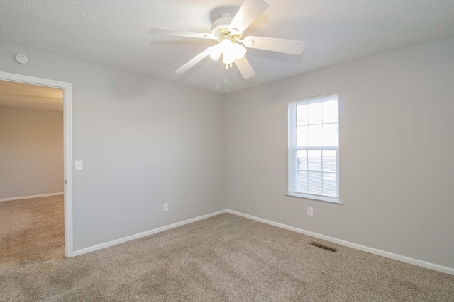 empty room with visible vents, baseboards, ceiling fan, a textured ceiling, and carpet floors