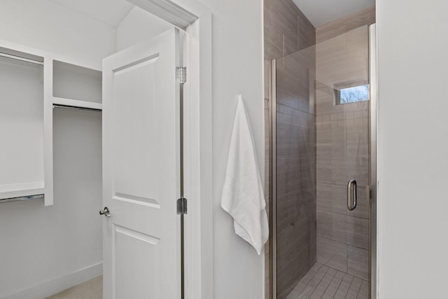 bathroom featuring a stall shower and baseboards