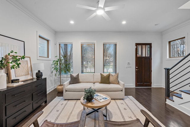 living area featuring dark wood-style flooring, stairway, and crown molding