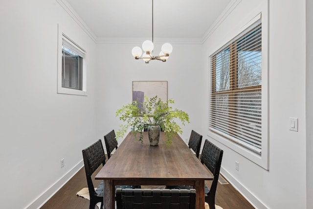 dining room with ornamental molding, dark wood finished floors, baseboards, and an inviting chandelier