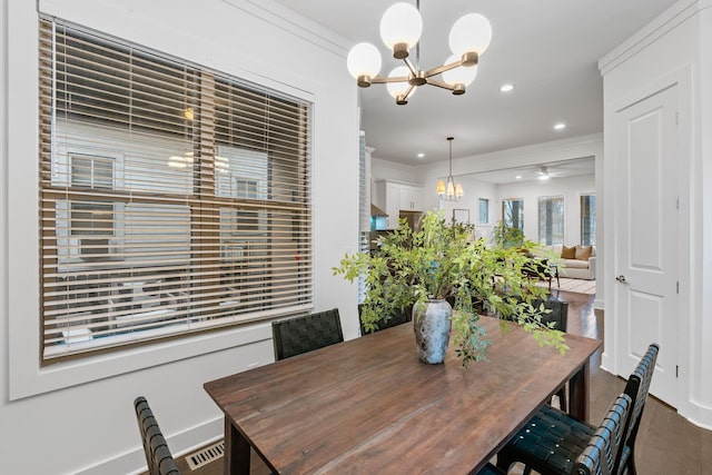 dining space featuring wood finished floors, crown molding, and recessed lighting