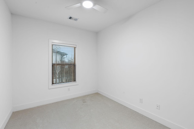 empty room with light carpet, ceiling fan, visible vents, and baseboards