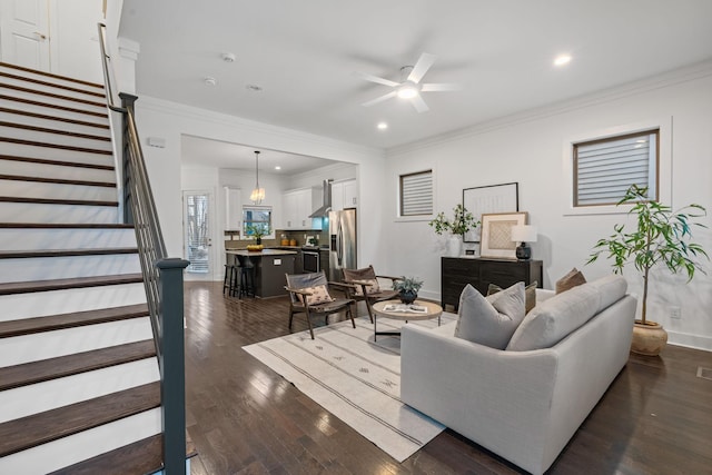 living area featuring dark wood-style floors, ornamental molding, stairway, and baseboards