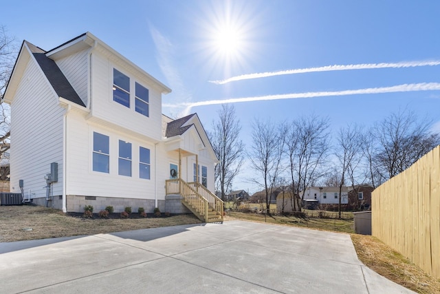 view of front facade featuring crawl space, fence, and central AC unit